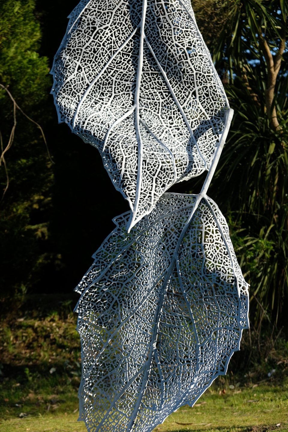 Detail of the sculpture joined set against a dark background to highlight the intricate open work pattern in the leaves