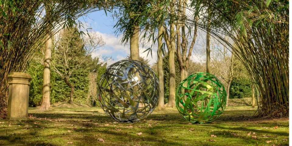 120cm diameter Calligraphy Ball in powder coat chrome colour and a 90cm diameter one in a metallic green finish under bamboo.