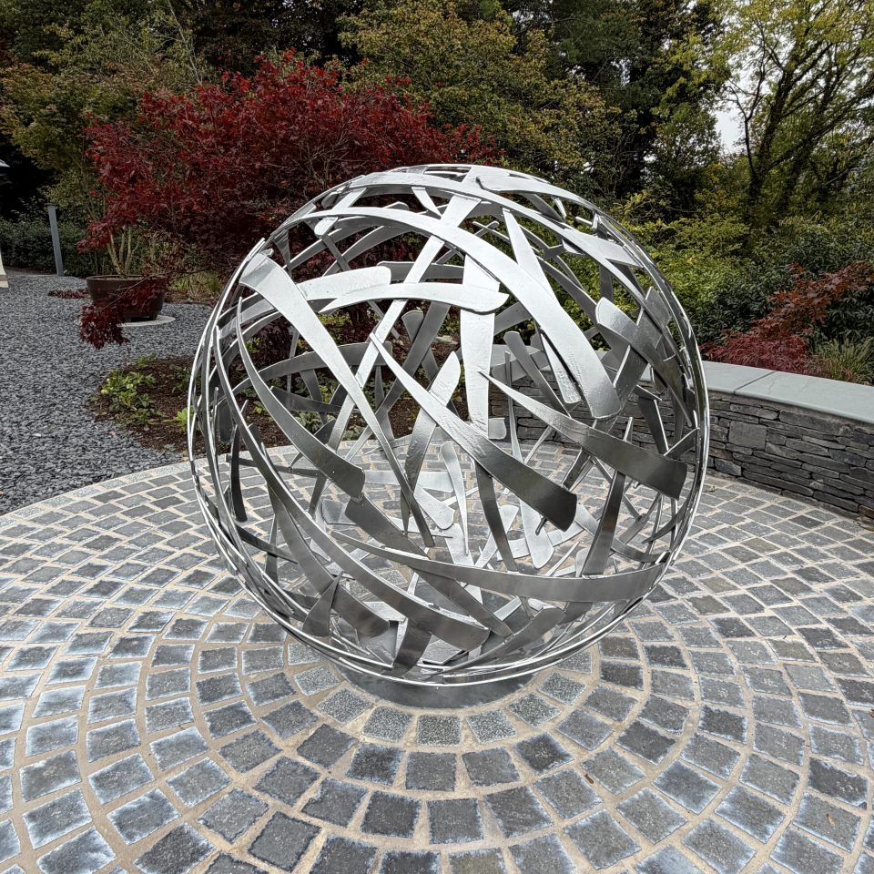 120cm diameter Calligraphy Ball, powder coat chrome colour finish set in the centre of a large circular plinth of slate sets